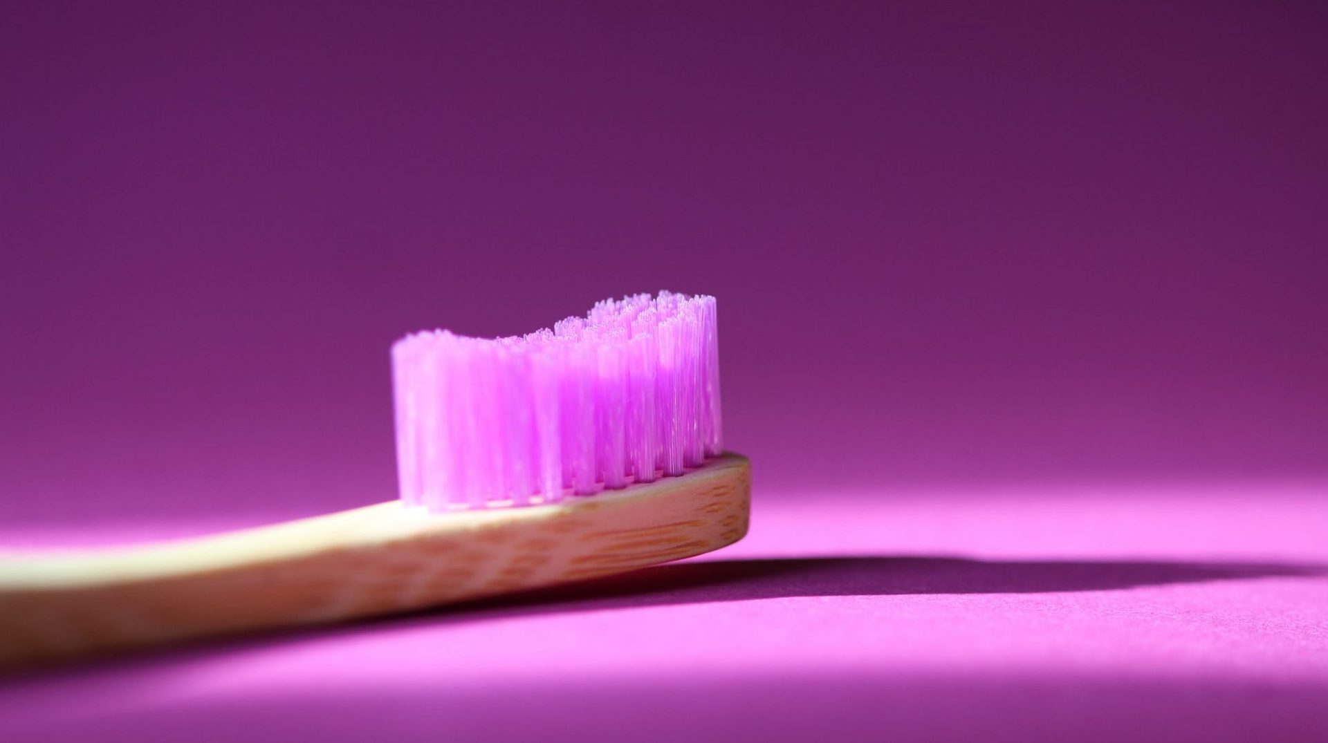 pink wooden toothbrush in pink background