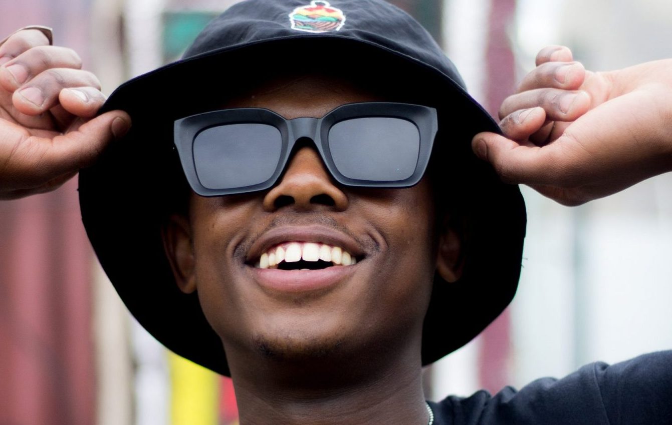 man in sunglasses and hat smiling
