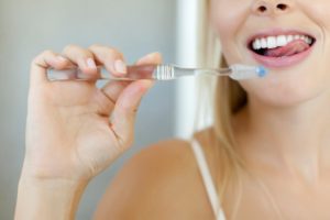 woman demonstrating how to brush your teeth