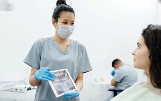 Dentist showing X-ray image of patients teeth to the patient