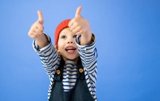 child giving two thumbs up