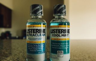 two bottles of mouthwash sitting on a counter