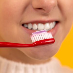 close up of teen brushing teeth