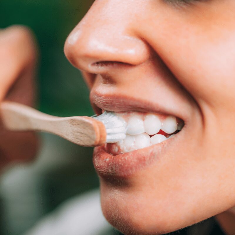 woman brushing her teeth with toothpaste tooth brush, with toothpaste