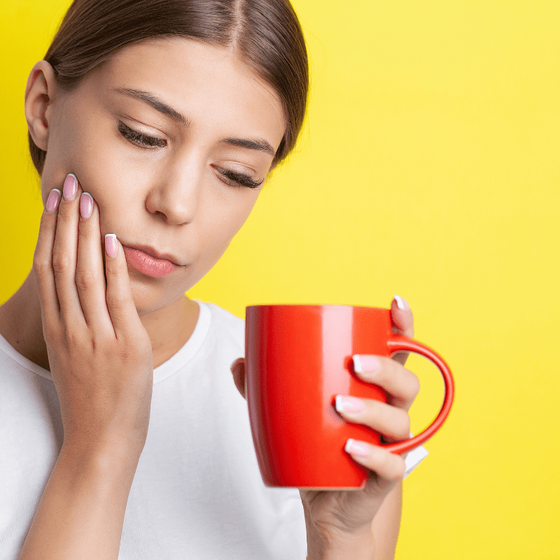 young woman, suffering from, tooth sensitivity, drinking coffee