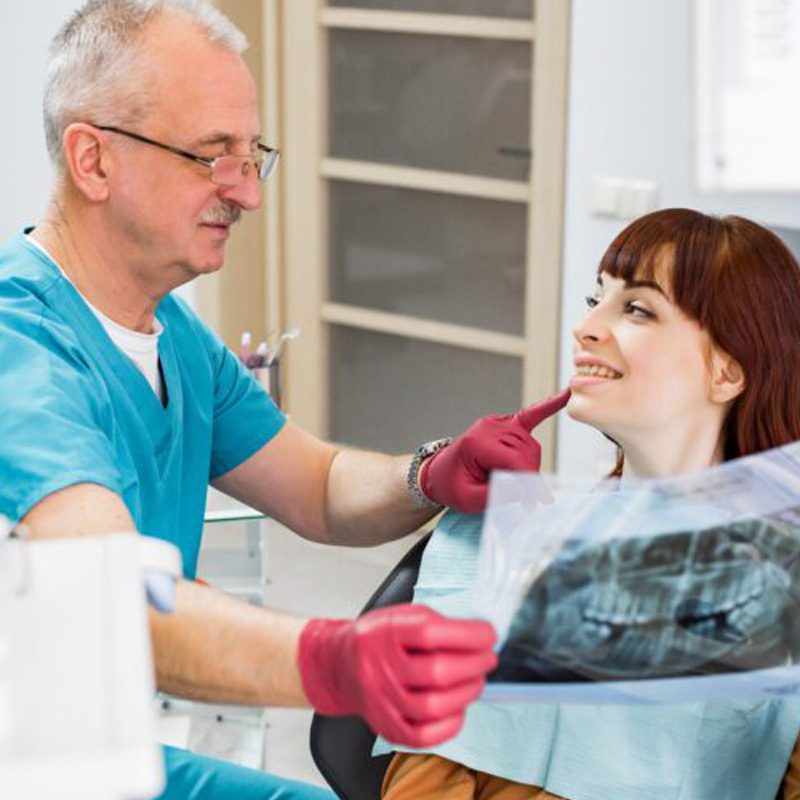 senior-dentist-going-over-dental-x-ray-with-patient