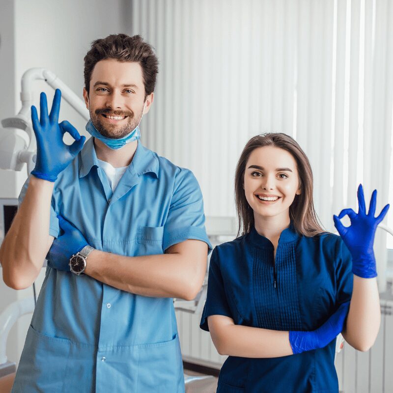 dentist and his assistant smiling