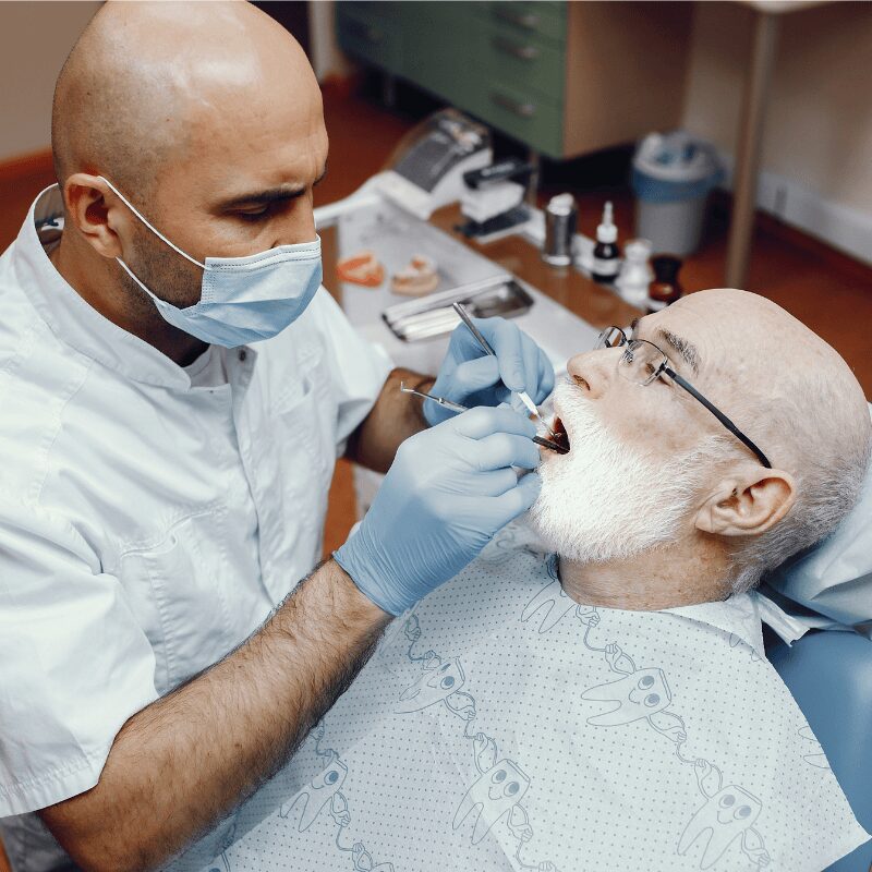 dentist restoring teeth for old man