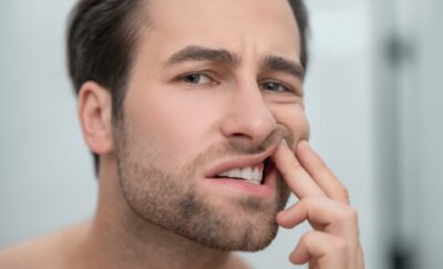 dental-problems-man-checking-his-teeth-looking-disturbed man wondering if gum disease will kill him