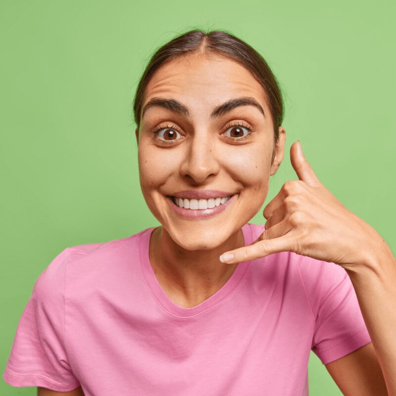 woman-shows-mobile-phone-gesture-call-me-sign- woman-shows-mobile-phone-gesture-call-me-sign-