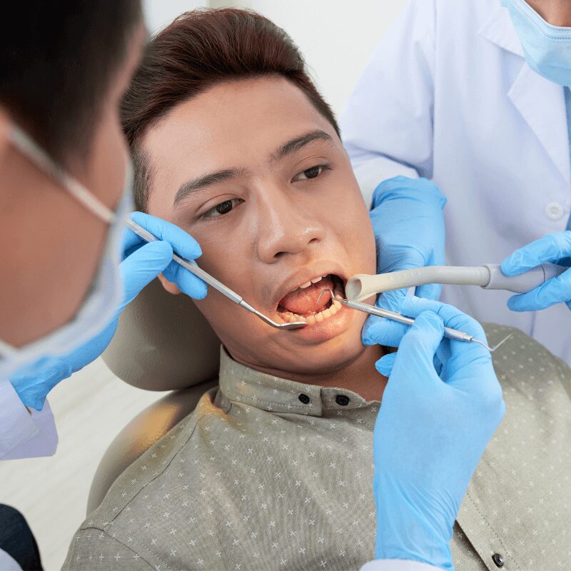 dentist examines asian man chipped tooth dentist examines asian man chipped tooth