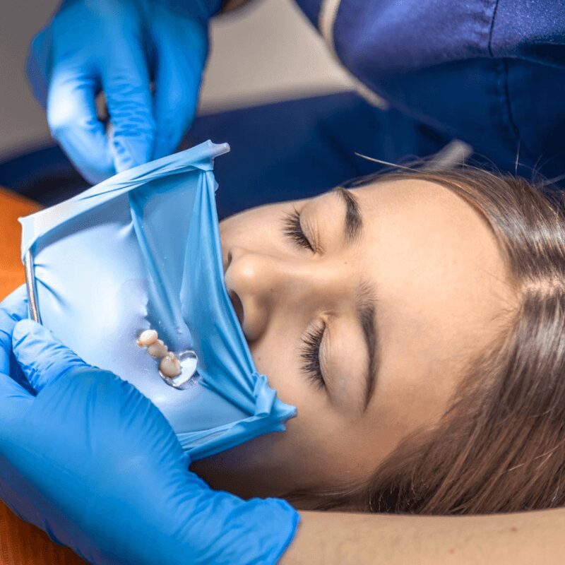 dentist examines first molar of female patient