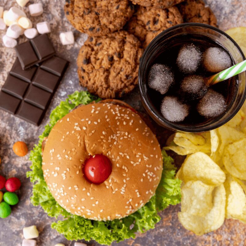 top view of unhealthy food, burger, soda, chocolate, chips, candy, cookies top view of unhealthy food, burger, soda, chocolate, chips, candy, cookies