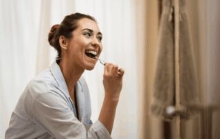 woman brushes her teeth after eating
