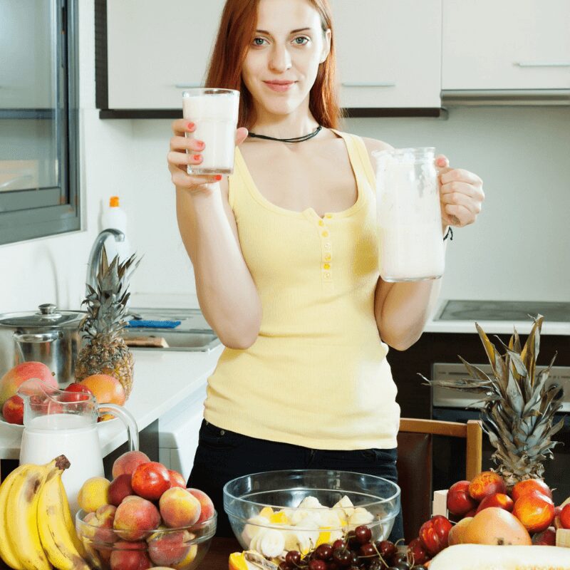 young girl holding glass and jug of milk, healthy food diet on the table