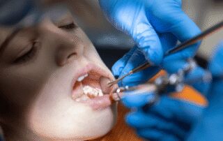 dentist examining patients teeth for tartar and plaque
