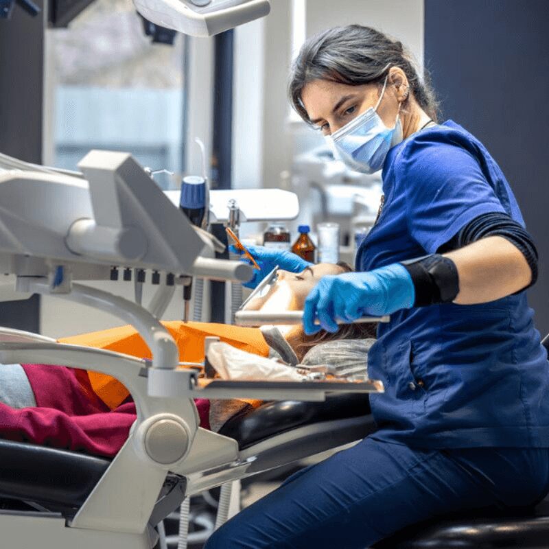 female dentist examines patients teeth