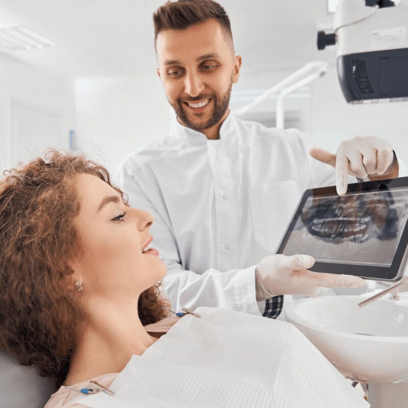 male-doctor-showing-xray-pictures- of girls' teeth